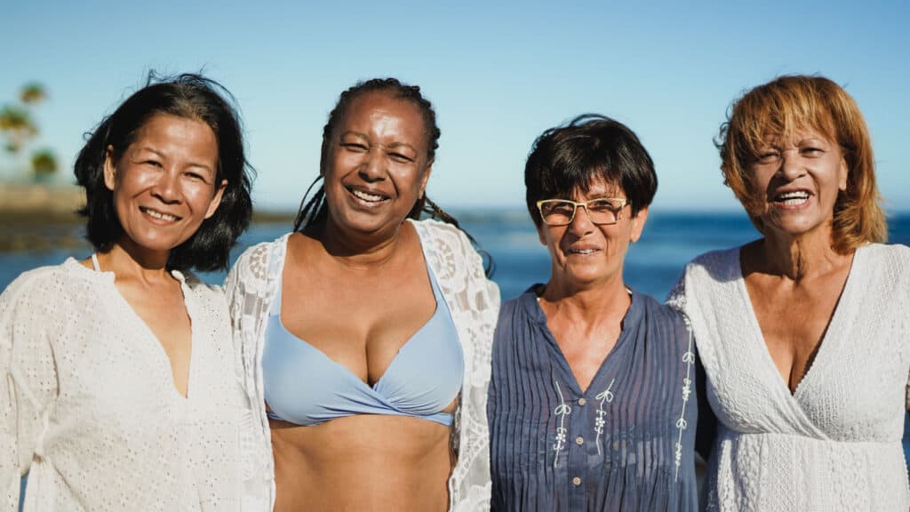 4 older women on beach.
