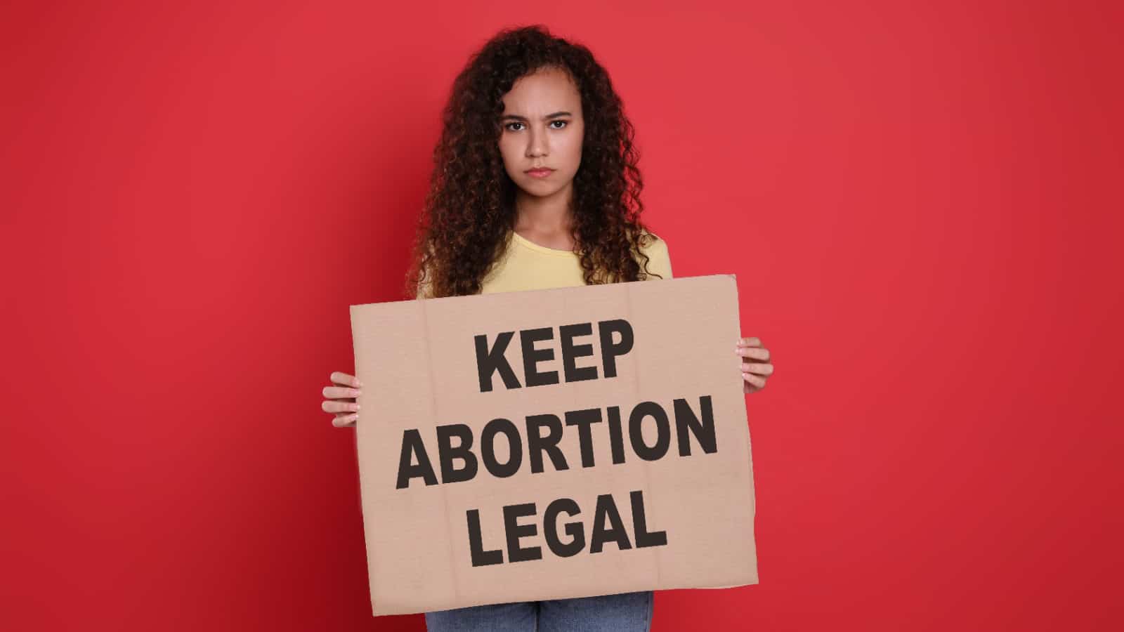 Woman holding Keep Abortion Legal sign.