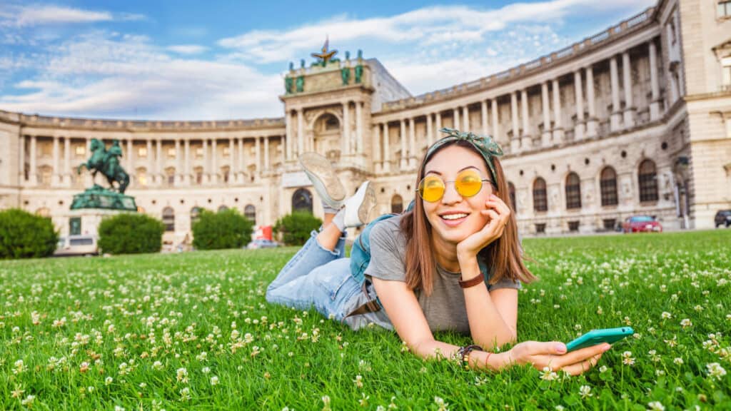 Young woman in Austria laying on grass. Image credit frantic00 via Shutterstock.