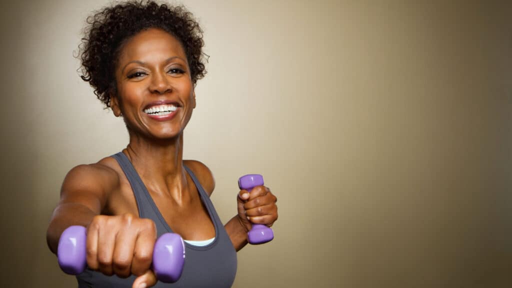 Beautiful black woman lifting weights. 