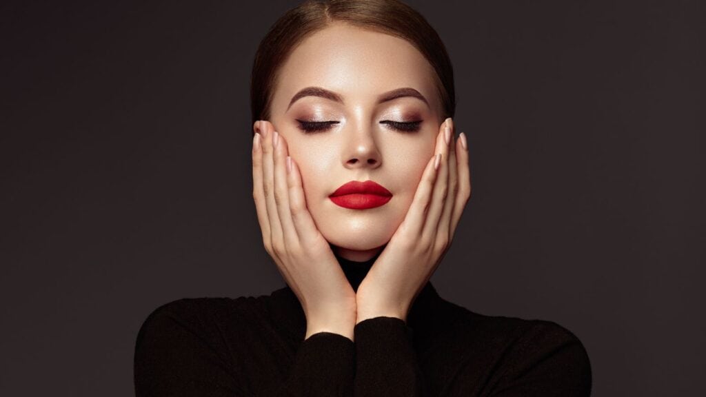 Beautiful woman wearing makeup against dark background.