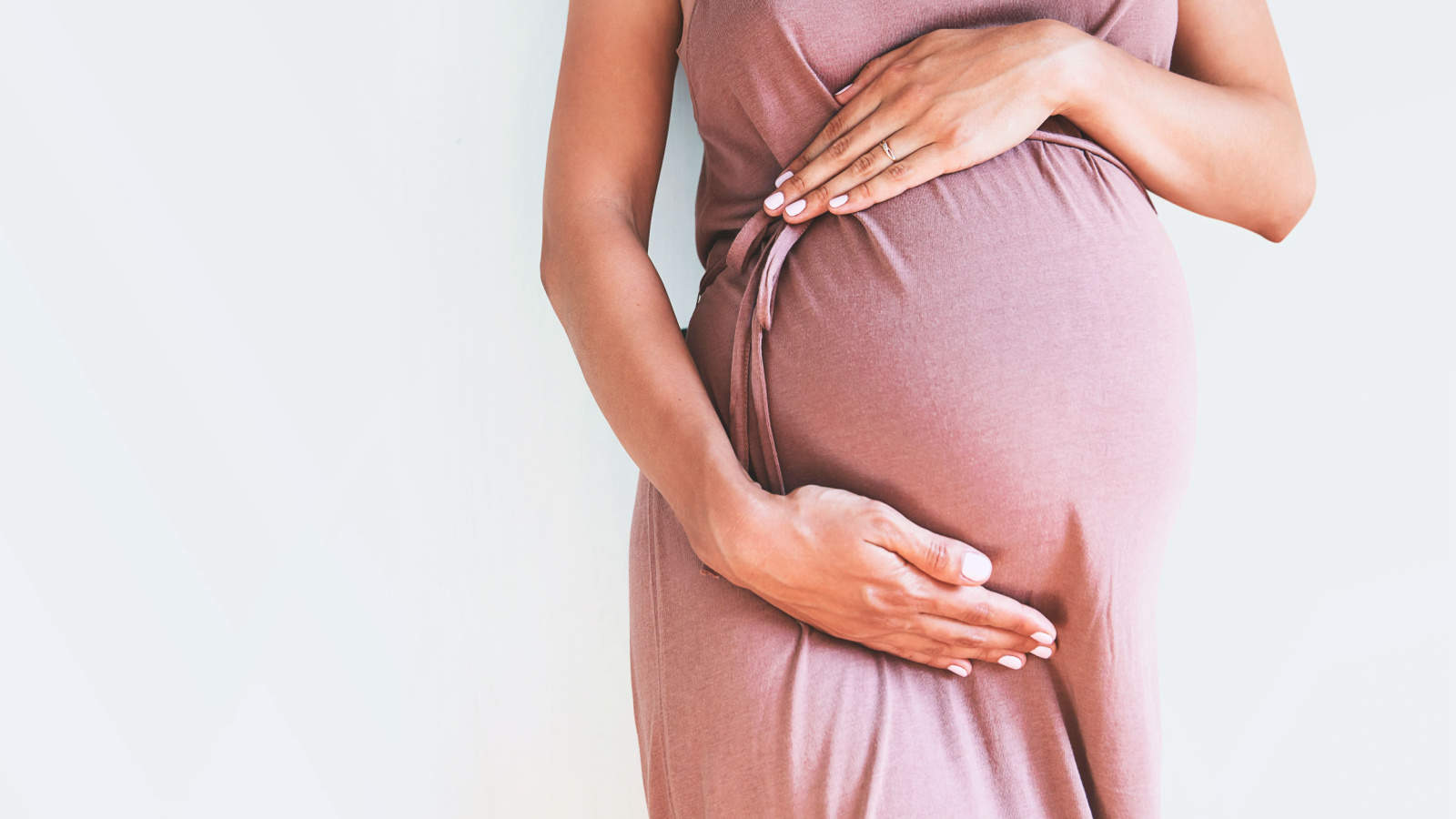 Pregnant woman holding belly.