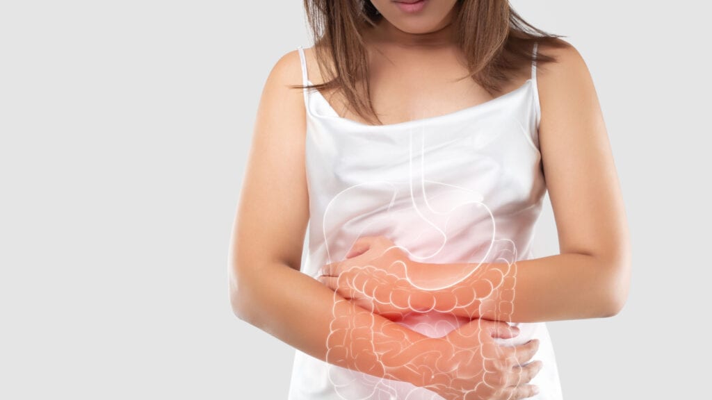 Young woman holding stomach with graphic if digestive tract.