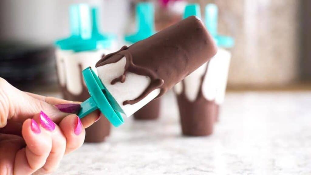 manicured-hand-holding-a-Low-FODMAP-Chocolate-Covered-Banana-Popsicle.