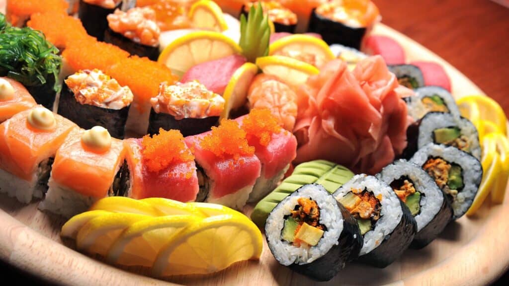 Assorted sushi on round platter. 