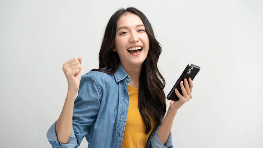 Happy woman using phone. Image credit Pormezz via Shutterstock.