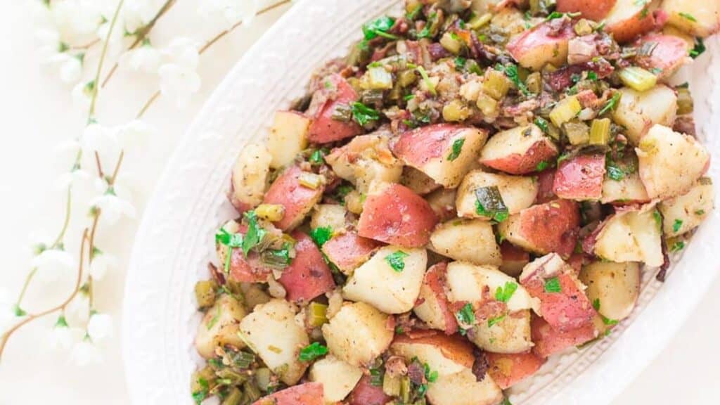 Hot-Potato-Salad-with-bacon-on-decorative-oval-white-platter.