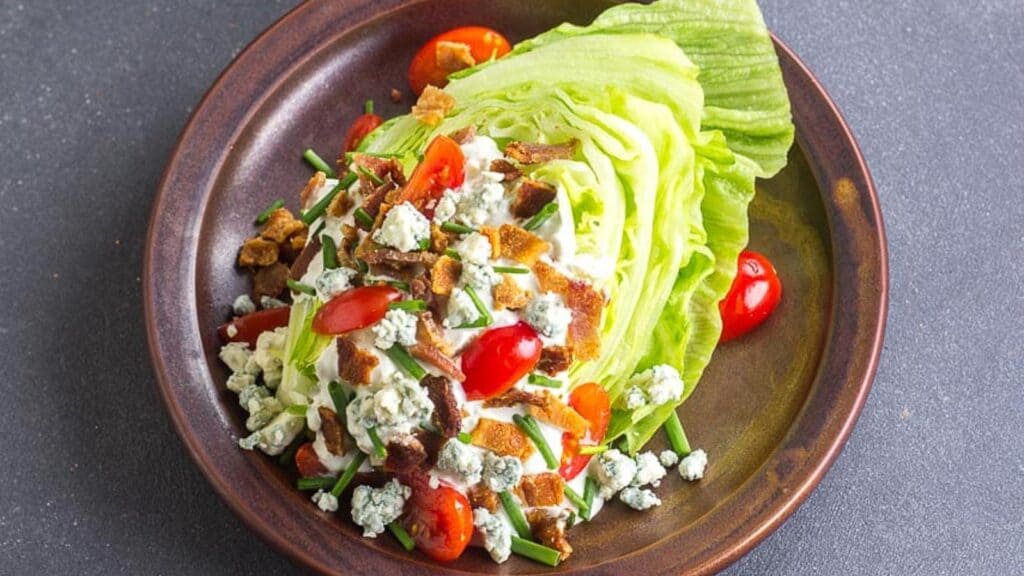 Wedge-Salad-with-bacon-and-tomatoes-on-ceramic-brown-plate-and-blue-cheese-dressing.