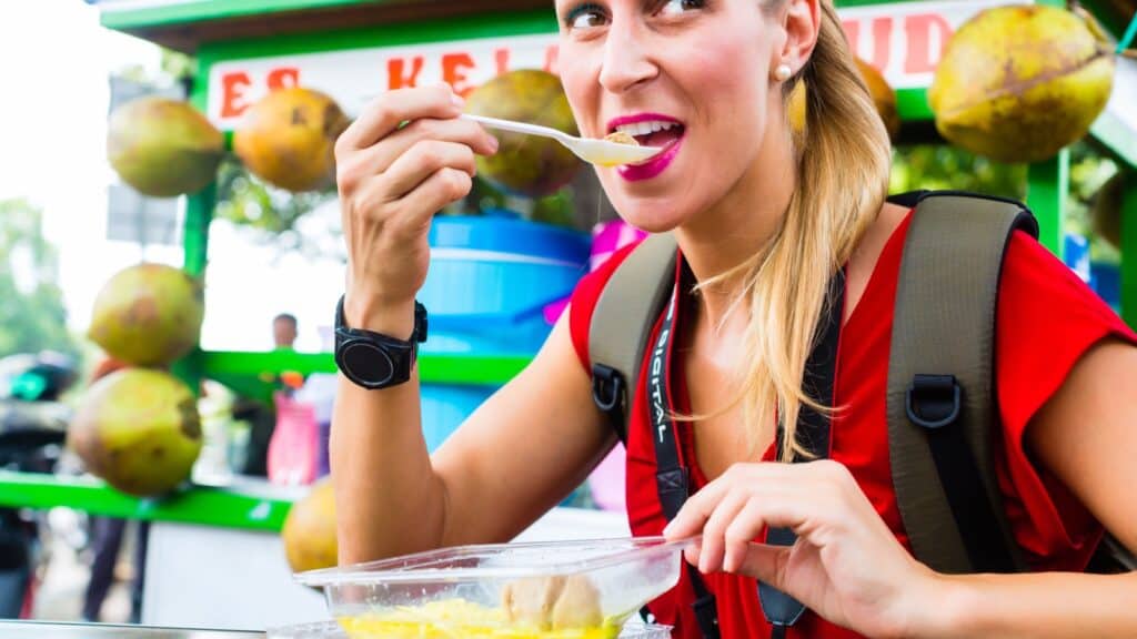 Woman eating food at market. 