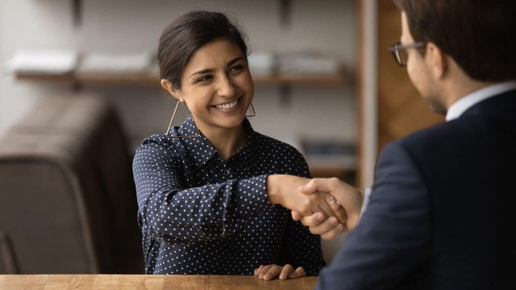 Woman shaking hands with interviewer.