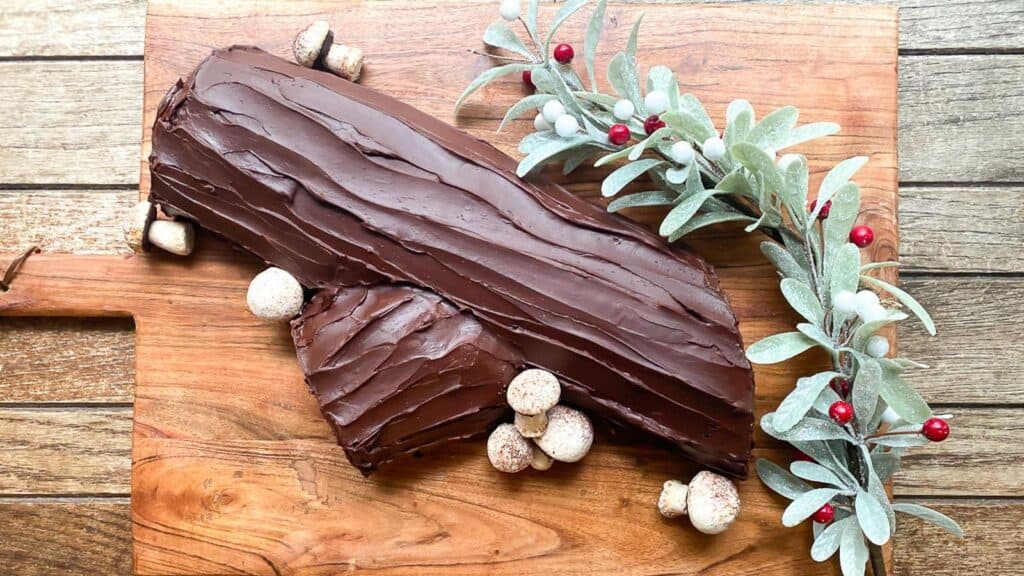 overhead-image-of-Low-FODMAP-Chocolate-Raspberry-Buche-de-Noel-on-wooden-board-with-meringue-mushrooms.