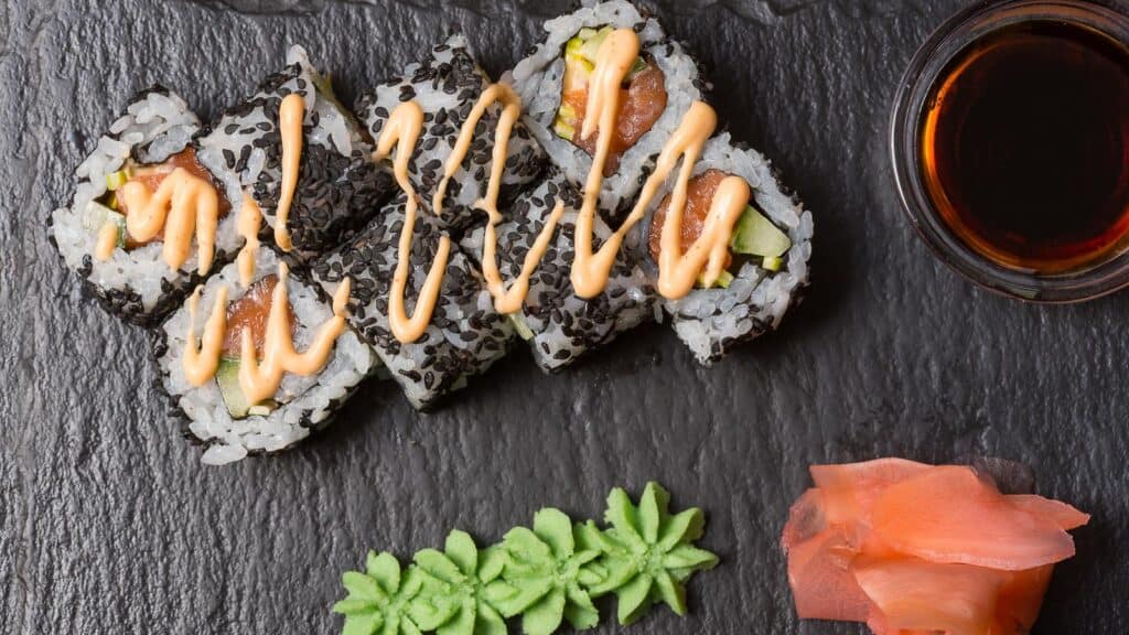 sushi-rolls-with-spicy-mayo-on-dark-background.