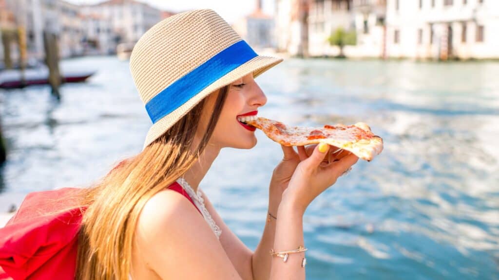 woman eating pizza in Italy.