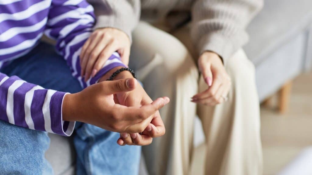 woman holding teenagers hand.