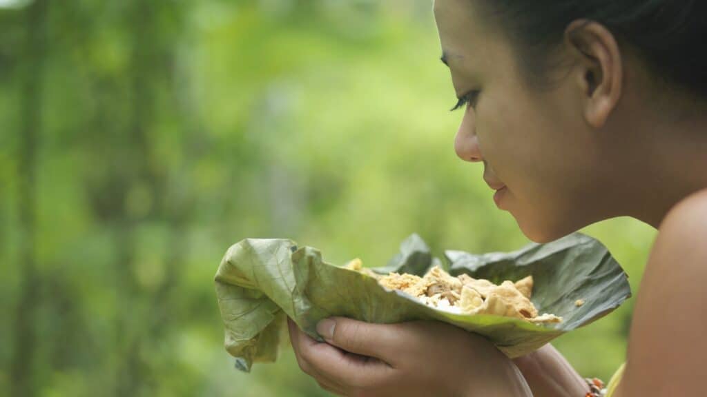 woman smelling food in leaf.