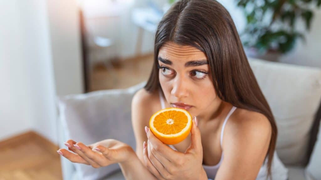 woman smelling orange.