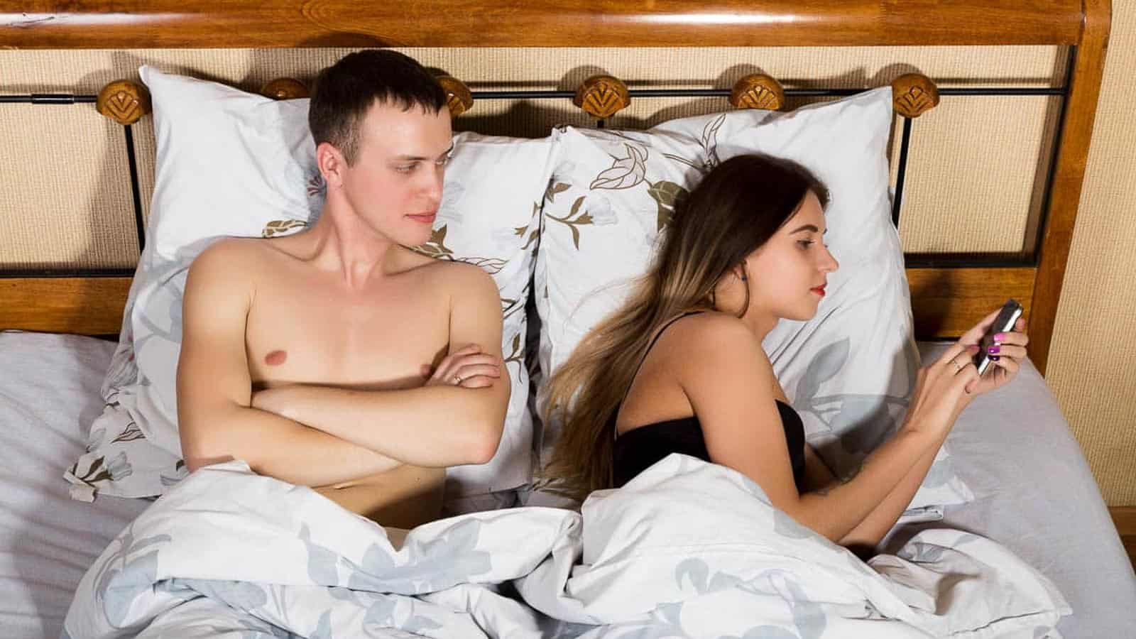woman-texting-with-man-in-bed-alongside-1.