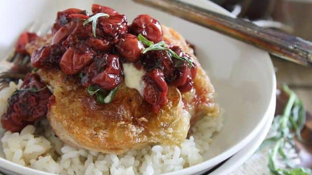 Fried-chicken-in-a-creamy-goat-cheese-sauce-topped-with-tarragon-tart-cherries.