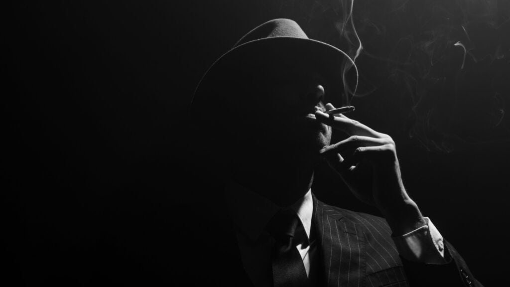 mafia. man in shadow. hat.