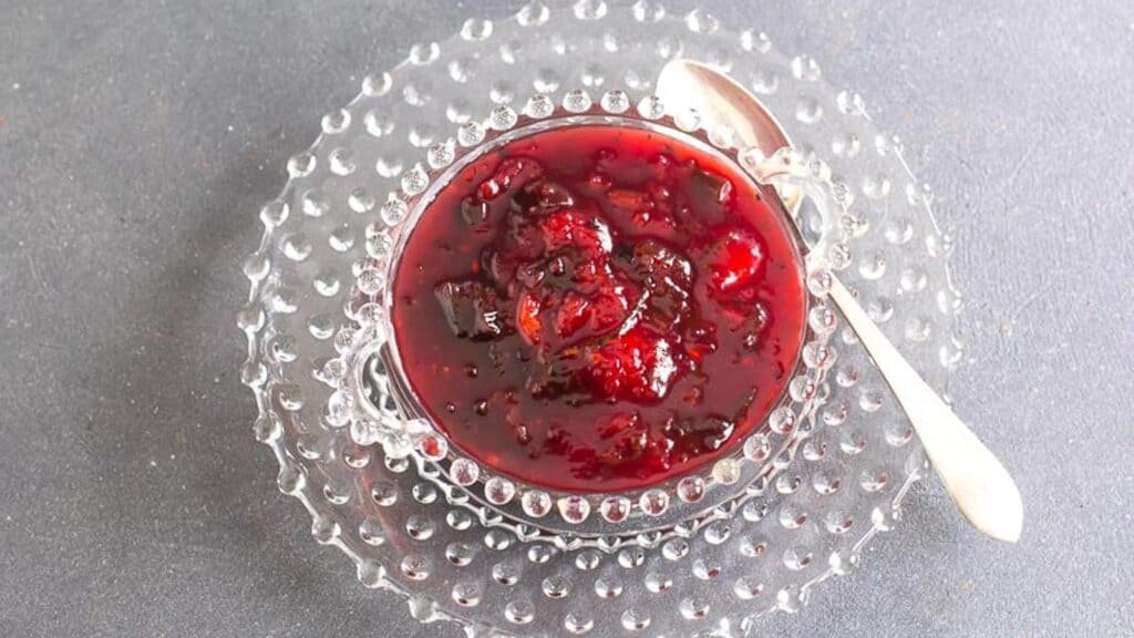 overhead-shot-of-Blackberry-and-Peach-Chutney-in-a-decorative-glass-bowl-with-silver-spoon.