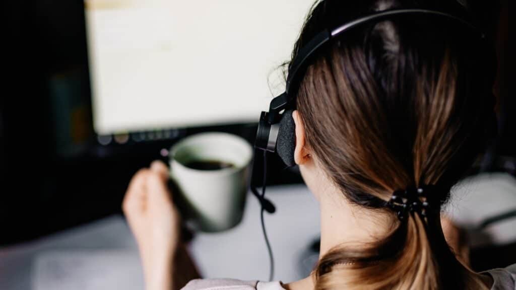 woman wearing headphones working on computer. 