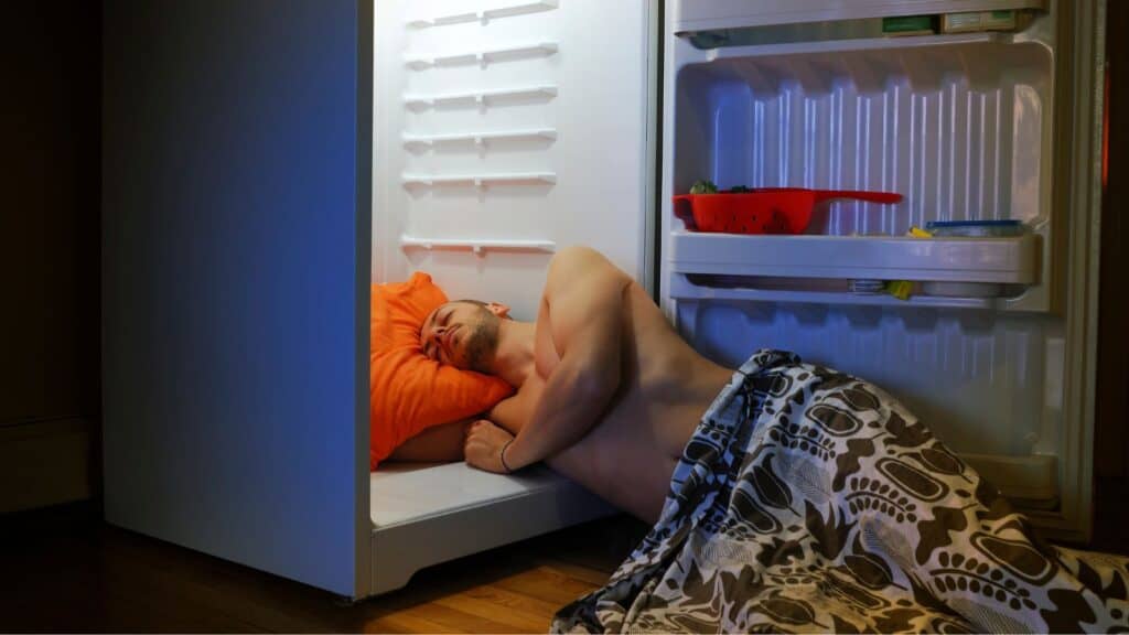 man laying in refrigerator cooling off