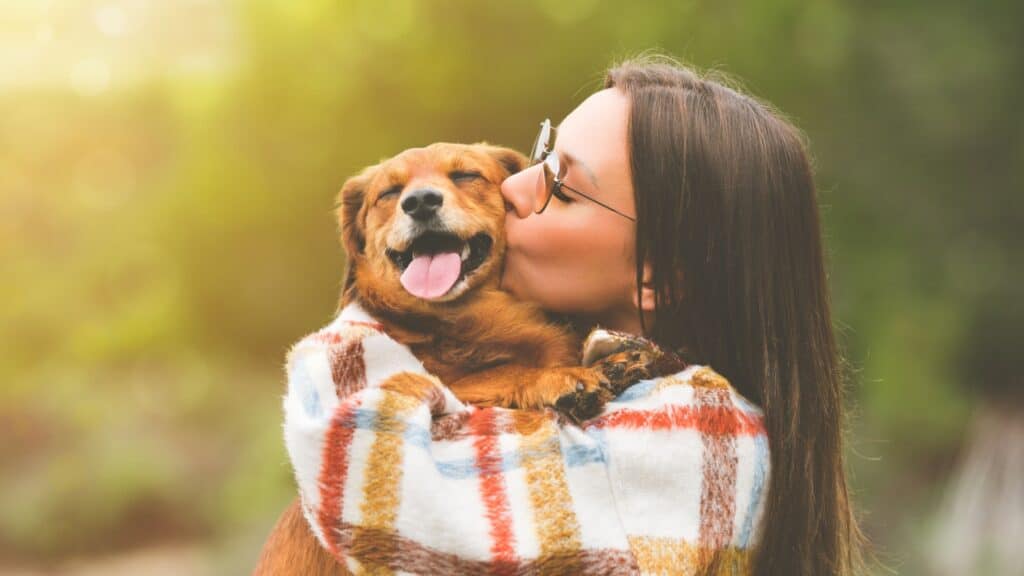 Woman and dog, hugging.