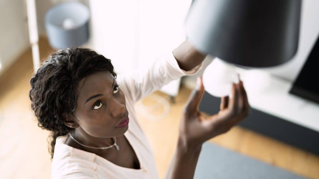 Woman changing LED bulb. 