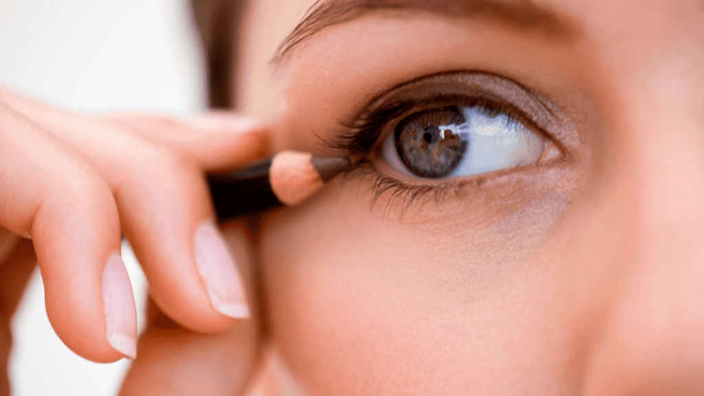 woman applying eyeliner makeup. 