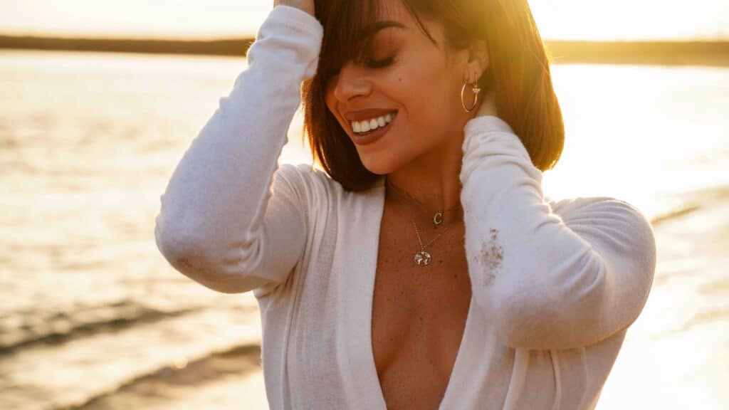 woman on beach wearing earrings. 