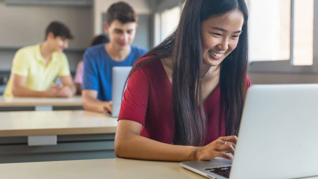 Girl student typing in laptop. 