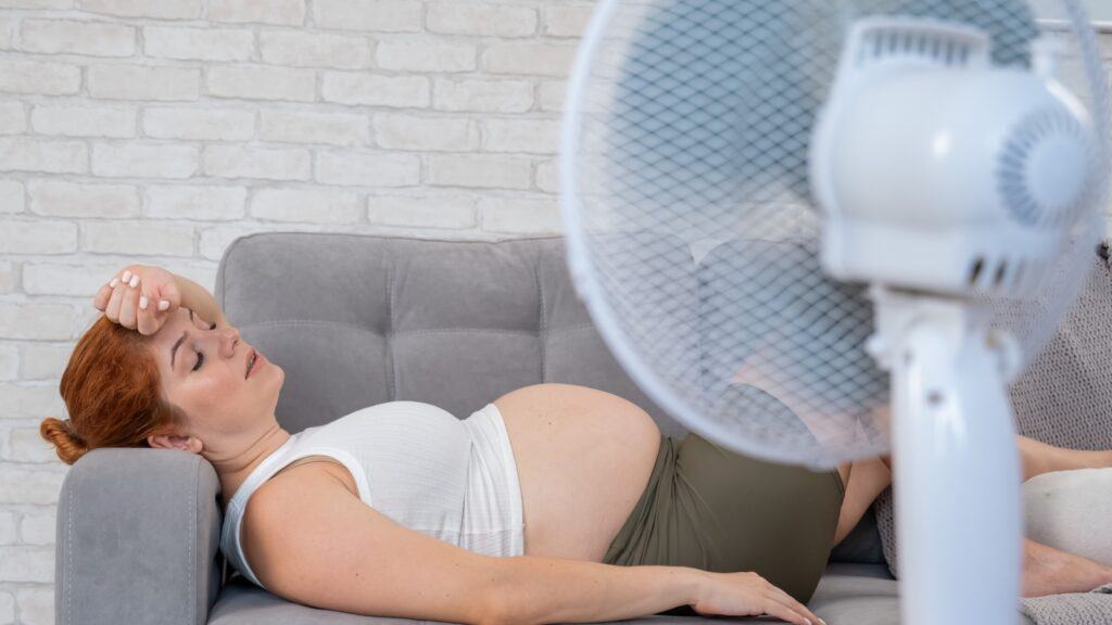 Hot pregnant woman with fan.