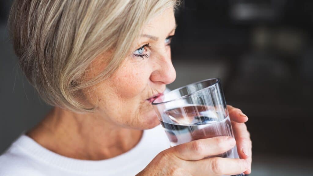 Older woman drinking water. 