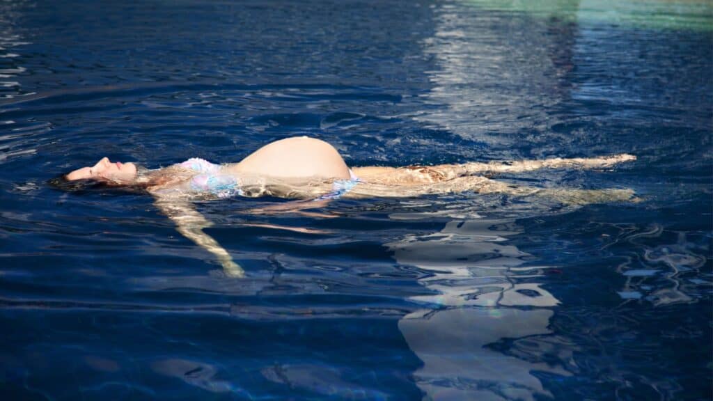 pregnant woman floating in water. 