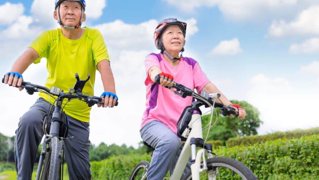 seniors in helmets on bikes.