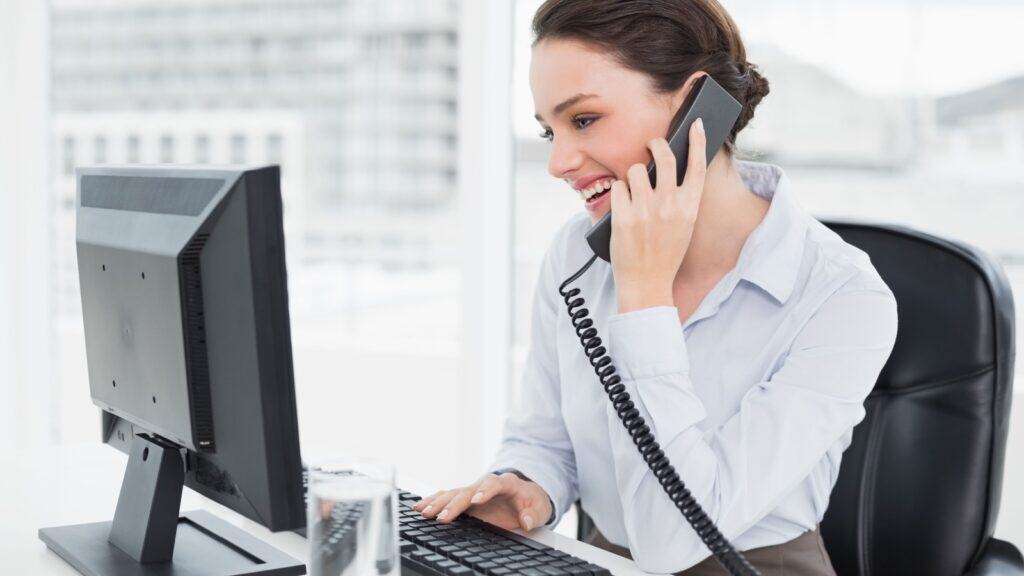 woman in office chair on phone at work. 