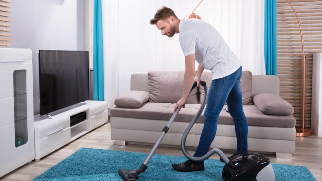 man vacuuming.